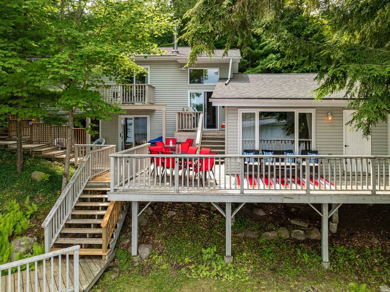 Deck with red dining chairs and lake view